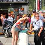 Officers protecting-and-serving a young lady in body paint, Sturgis Rally 2015