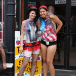 Ladies on Sturgis Main Street advertising for a tattoo parlor in body paint