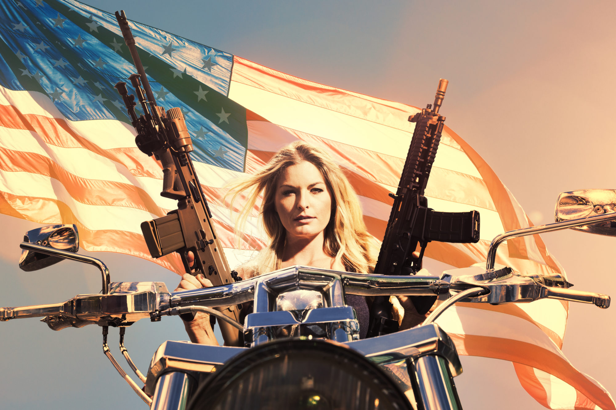 Woman Holds Automatic Weapons While Sitting on Motorcyle